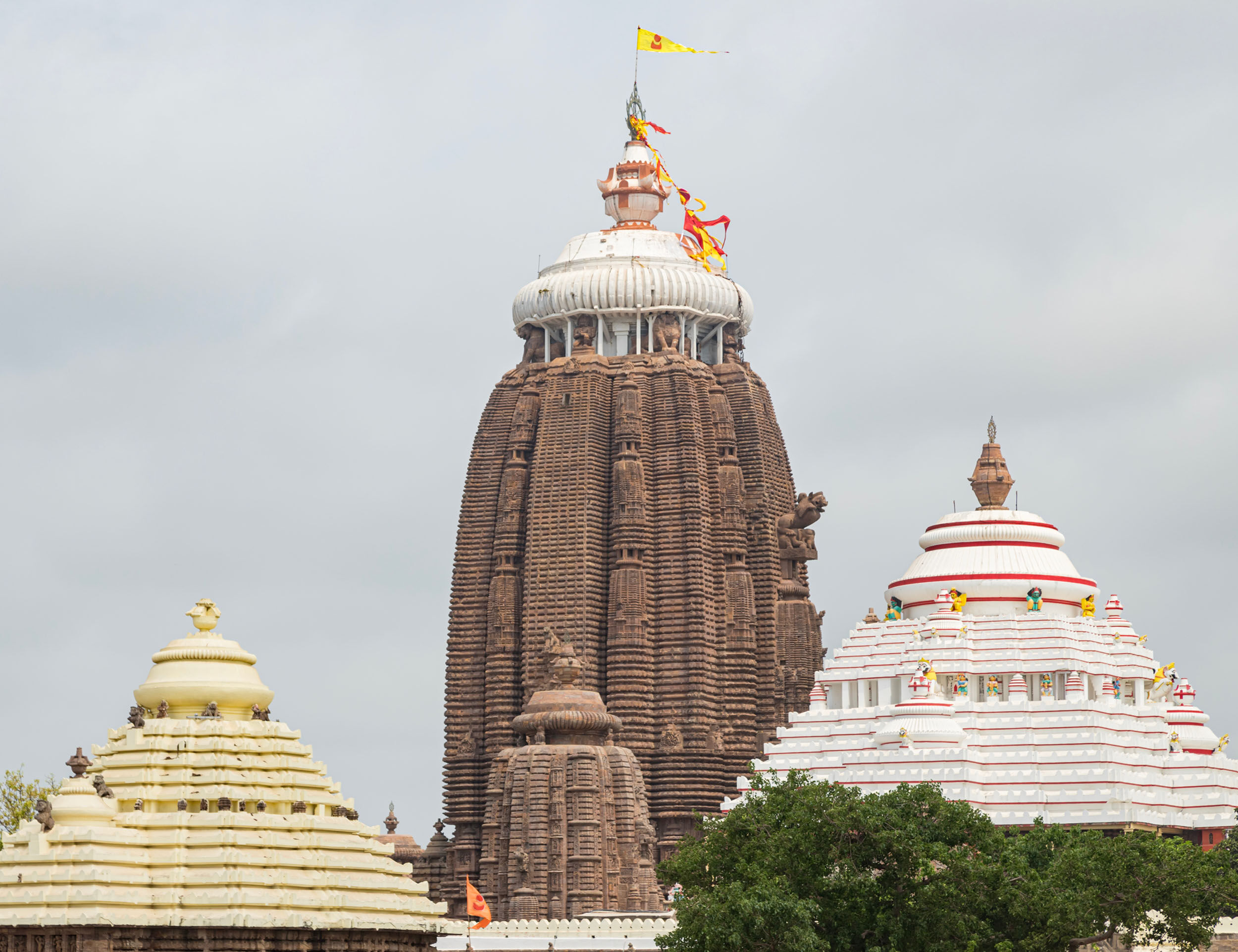 Shree Jagannath Temple in Puri, Odisha adorned with flags ahead of the Rath Yatra festival celebrations under a cloudy sky.